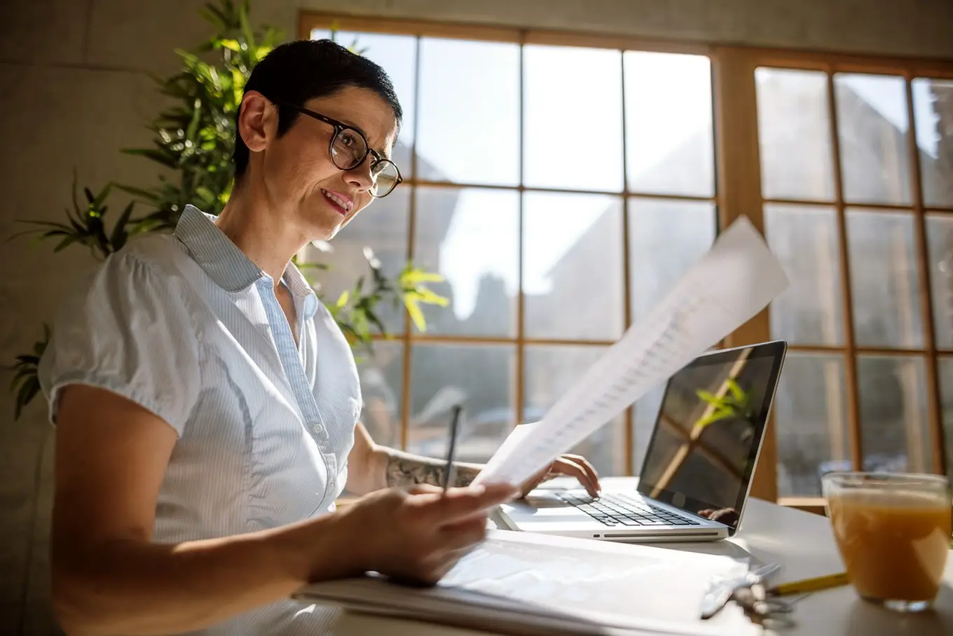 kobieta z dokumentami przed laptopem